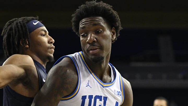 Nov 22, 2024; Los Angeles, California, USA; UCLA Bruins guard Eric Dailey Jr. (3) dribbles to the basket as Cal State Fullerton Titans guard Freddie Cooper (2) defends during the second half at Pauley Pavilion presented by Wescom. Mandatory Credit: Robert Hanashiro-Imagn Images
