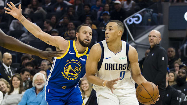 Feb 23, 2025; San Francisco, California, USA; Dallas Mavericks guard Dante Exum (0) drives past Golden State Warriors guard Stephen Curry (30) during the first quarter at Chase Center. Mandatory Credit: John Hefti-Imagn Images