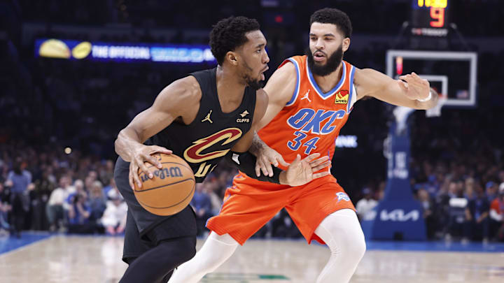 Jan 16, 2025; Oklahoma City, Oklahoma, USA;Cleveland Cavaliers guard Donovan Mitchell (45) drives around Oklahoma City Thunder forward Kenrich Williams (34) during the second quarter at Paycom Center. Mandatory Credit: Alonzo Adams-Imagn Images