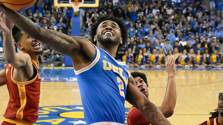 Feb 24, 2026; Los Angeles, California, USA; UCLA Bruins guard Donovan Dent (2) grabs a rebound away from Southern California Trojans guard Chad Baker-Mazara (4) during the first half at Pauley Pavilion presented by Wescom Financial. Mandatory Credit: Robert Hanashiro-Imagn Images