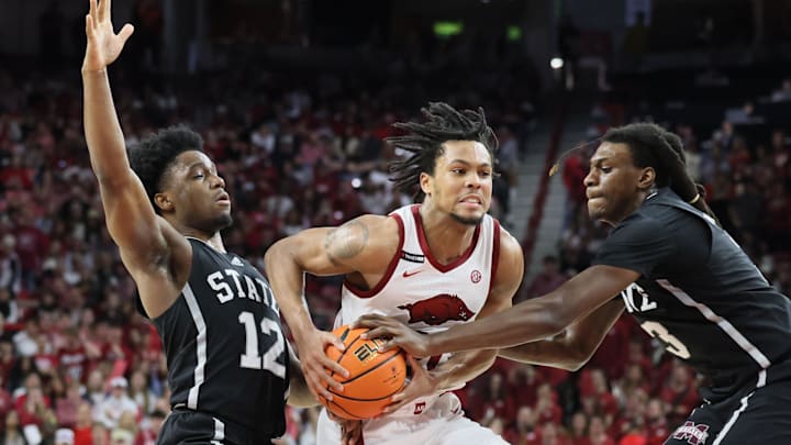 Arkansas Razorbacks guard D.J. Wagner (21) drives between Mississippi State Bulldogs guard Josh Hubbard (12) and forward KeShawn Murphy (3) during the first half at Bud Walton Arena in Fayetteville, Ark.