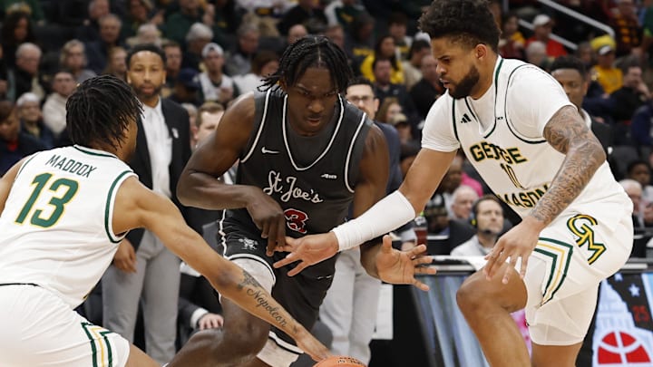 Mar 15, 2025; Washington, D.C., USA; Saint Joseph's Hawks forward Rasheer Fleming (13) attempts to dribble the ball between George Mason Patriots guard Darius Maddox (13) and Patriots forward Zach Anderson (10) in the first halfat Capital One Arena. Mandatory Credit: Geoff Burke-Imagn Images
