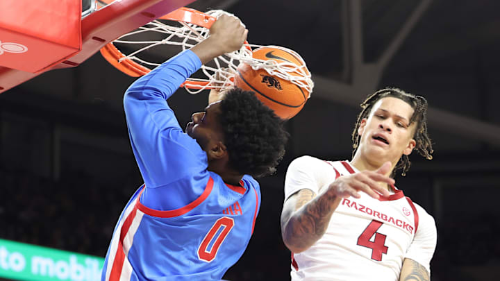 Ole Miss Rebels forward Malik Dia (0) dunks the ball as Arkansas Razorbacks forward Trevon Brazile (4) defends during the first half at Bud Walton Arena. 