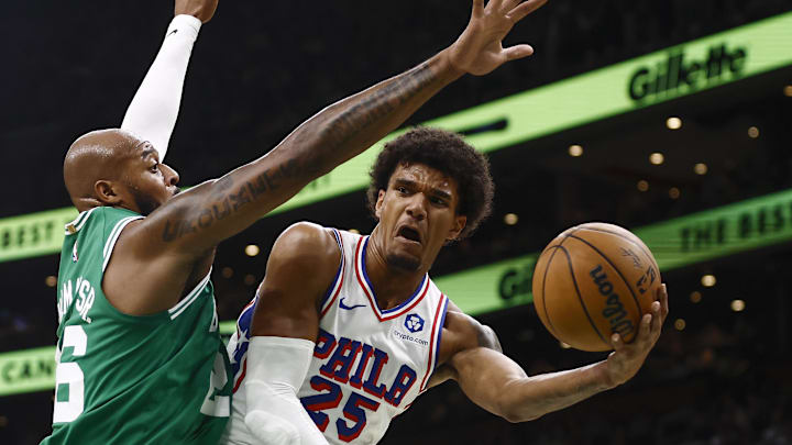 Oct 22, 2025; Boston, Massachusetts, USA; Philadelphia 76ers forward Dominick Barlow (25) passes around Boston Celtics forward Xavier Tillman (26) during the first quarter at TD Garden. Mandatory Credit: Winslow Townson-Imagn Images