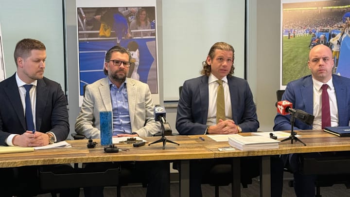 Detroit Lions fan Ryan Kennedy sits next to attorney Jonathan Marko to discuss $100 million lawsuit