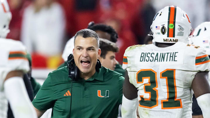 Jan 19, 2026; Miami Gardens, FL, USA; Miami Hurricanes head coach Mario Cristobal with linebacker Wesley Bissainthe (31) against the Indiana Hoosiers during the College Football Playoff National Championship game at Hard Rock Stadium. Mandatory Credit: Mark J. Rebilas-Imagn Images Jan 19, 2026; Miami Gardens, FL, USA; Miami Hurricanes head coach Mario Cristobal with linebacker Wesley Bissainthe (31) against the Indiana Hoosiers during the College Football Playoff National Championship game at Hard Rock Stadium. Mandatory Credit: Mark J. Rebilas-Imagn Images