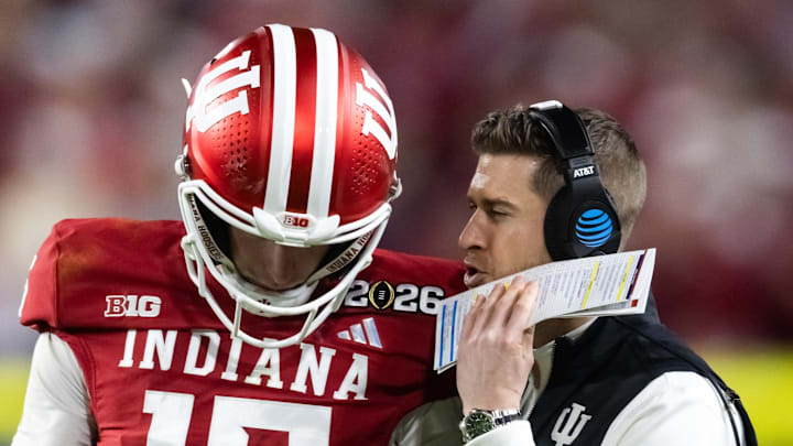 Jan 19, 2026; Miami Gardens, FL, USA; Indiana Hoosiers quarterback Fernando Mendoza (15) with quarterbacks coach Chandler Whitmer against the Miami Hurricanes in the College Football Playoff National Championship game at Hard Rock Stadium. Mandatory Credit: Mark J. Rebilas-Imagn Images
