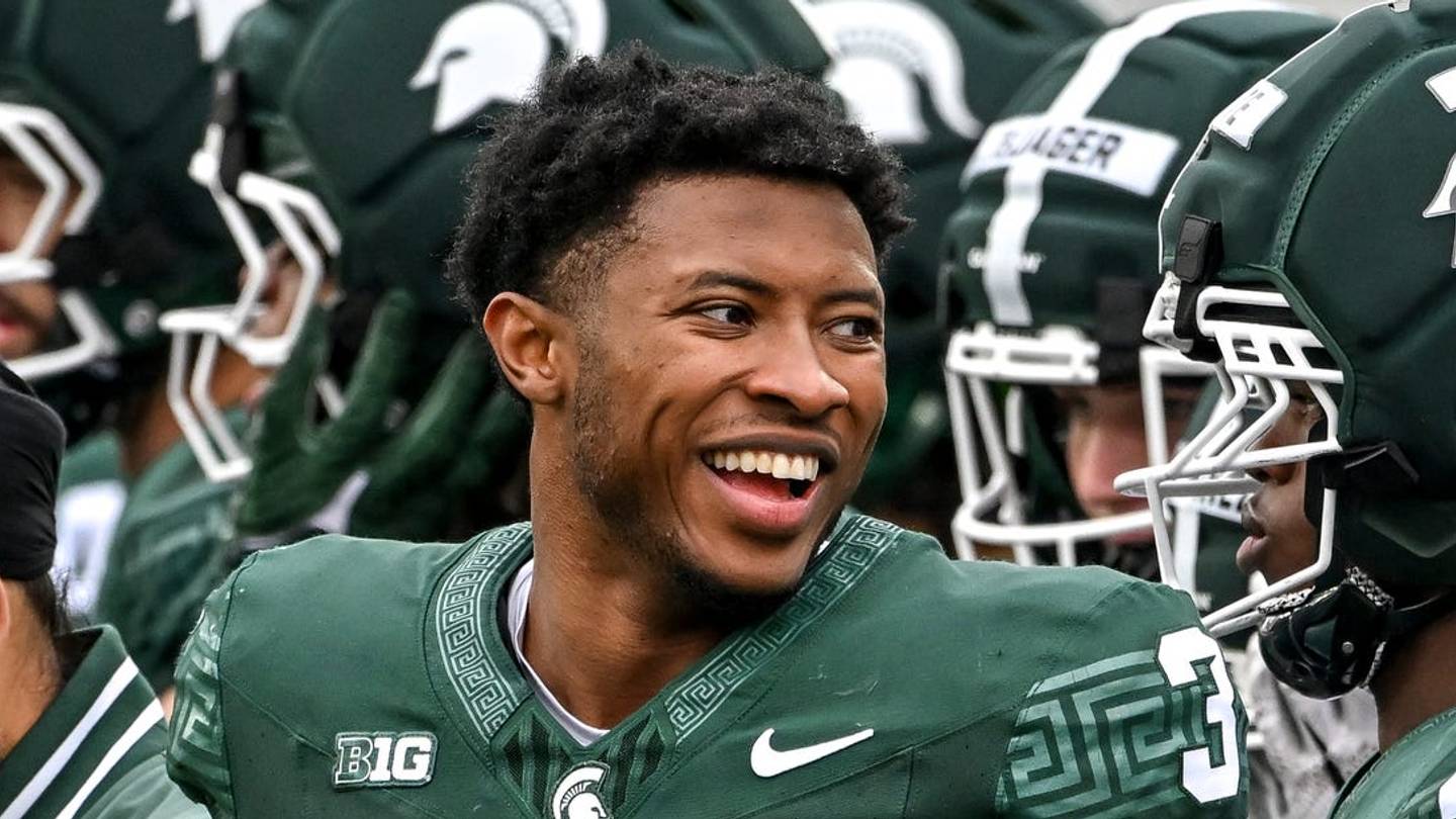 Michigan State football players practice at Spartan Stadium with new transfers in the background