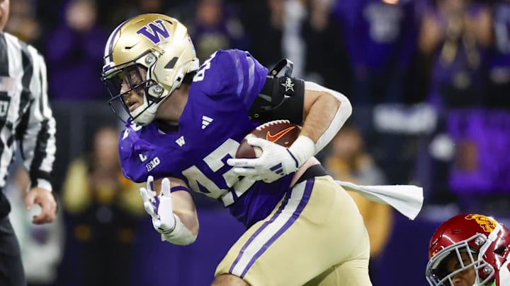 Nov 2, 2024; Seattle, Washington, USA; Washington Huskies linebacker Carson Bruener (42) returns an interception against USC Trojans wide receiver JaKobi Lane (8) during the third quarter at Alaska Airlines Field at Husky Stadium. Mandatory Credit: Joe Nicholson-Imagn Images