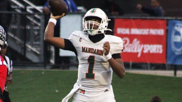 Mandarin quarterback Tramell Jones (1) prepares to toss a short pass over Miami Columbus pass rusher Willis McGahee IV (17) during the FHSAA Class 4M high school football championship game on December 8, 2023. [Clayton Freeman/Florida Times-Union]