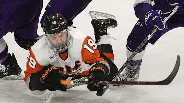 File Photo; Former RIT forward Nick Bruce takes a rough hit while being surrounded by three Niagara players. 