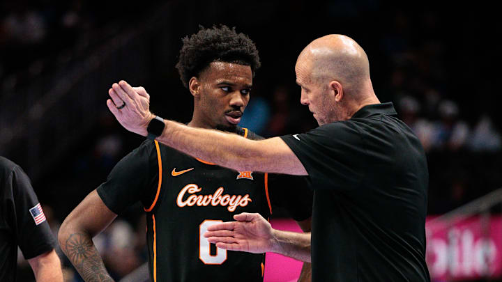 Mar 11, 2026; Kansas City, MO, USA; Oklahoma State Cowboys coach Steve Lutz speaks with Oklahoma State Cowboys guard Jaylen Curry (0) during the first half against the TCU Horned Frogs at T-Mobile Center. Mandatory Credit: William Purnell-Imagn Images