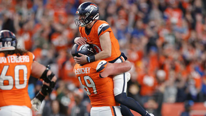 Dec 14, 2025; Denver, Colorado, USA; Denver Broncos quarterback Bo Nix (10) celebrates a touchdown with offensive tackle Mike McGlinchey (69) during the third quarter against the Green Bay Packers at Empower Field at Mile High. 