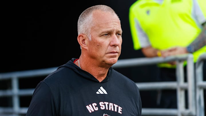 Aug 28, 2025; Raleigh, North Carolina, USA; North Carolina State Wolfpack head coach Dave Doeren walks out during the warmups prior to the game against East Carolina Pirates at Carter-Finley Stadium. Mandatory Credit: Jaylynn Nash-Imagn Images