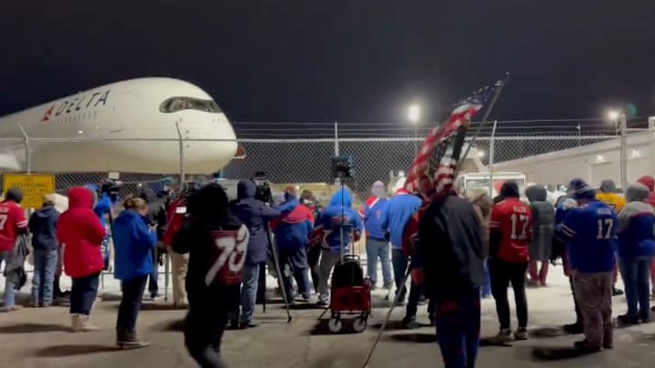 Buffalo Bills fans wait at the airport for the team to arrive back.