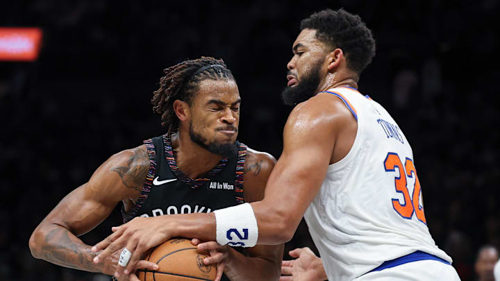 Nov 24, 2025; Brooklyn, New York, USA; Brooklyn Nets center Nic Claxton (33) drives to the basket against New York Knicks center Karl-Anthony Towns (32) during the second half at Barclays Center. Mandatory Credit: Vincent Carchietta-Imagn Images