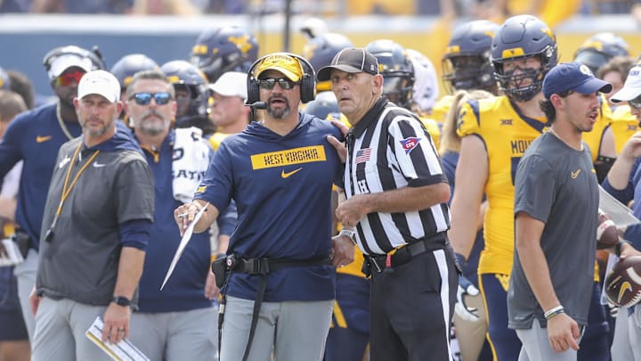 Aug 31, 2024; Morgantown, West Virginia, USA; West Virginia Mountaineers head coach Neal Brown talks to a referee during the second quarter against the Penn State Nittany Lions at Mountaineer Field at Milan Puskar Stadium. Mandatory Credit: Ben Queen-Imagn Images