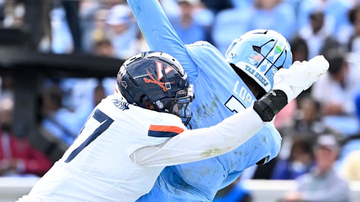 Oct 25, 2025; Chapel Hill, North Carolina, USA; North Carolina Tar Heels quarterback Gio Lopez (7) passes the ball as Virginia Cavaliers defensive end Mitchell Melton (17) pressures in the third quarter at Kenan Stadium. 