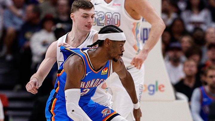 May 15, 2025; Denver, Colorado, USA; Oklahoma City Thunder guard Shai Gilgeous-Alexander (2) controls the ball as Denver Nuggets guard Christian Braun (0) guards in the third quarter during game six of the second round for the 2025 NBA Playoffs at Ball Arena. Mandatory Credit: Isaiah J. Downing-Imagn Images
