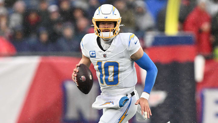Dec 3, 2023; Foxborough, Massachusetts, USA; Los Angeles Chargers quarterback Justin Herbert (10) runs with the ball against the New England Patriots during the first half at Gillette Stadium. Mandatory Credit: Brian Fluharty-Imagn Images