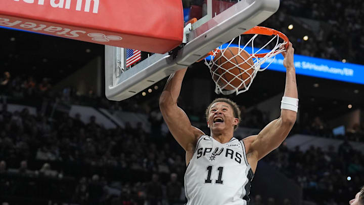 Jan 19, 2026; San Antonio, Texas, USA; San Antonio Spurs forward Carter Bryant (11) dunks the ball against Utah Jazz center Jusuf Nurkić (30) during the second half at Frost Bank Center.