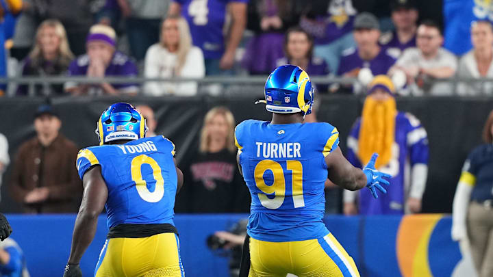 Jan 13, 2025; Glendale, AZ, USA; Los Angeles Rams defensive tackle Kobie Turner (91) reacts after making a sack on Minnesota Vikings quarterback Sam Darnold (14) during the first half in an NFC wild card game at State Farm Stadium. Mandatory Credit: Joe Camporeale-Imagn Images Jan 13, 2025; Glendale, AZ, USA; Los Angeles Rams defensive tackle Kobie Turner (91) reacts after making a sack on Minnesota Vikings quarterback Sam Darnold (14) during the first half in an NFC wild card game at State Farm Stadium. Mandatory Credit: Joe Camporeale-Imagn Images