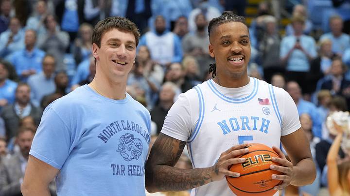 Jan 21, 2023; Chapel Hill, North Carolina, USA; Former North Carolina Tar Heels great Tyler Hansbrough presents forward Armando Bacot (5) with the game ball after the game. Bacot became the all-time Tar Heels rebounding leader during the game breaking Hansbrough’s record. Mandatory Credit: Bob Donnan-USA TODAY Sports