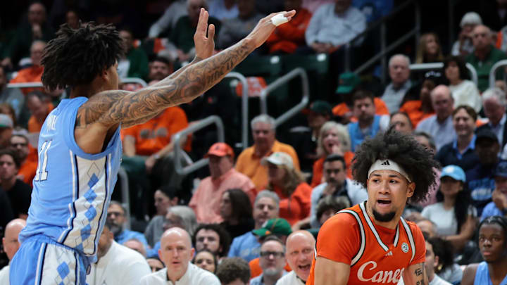 Feb 10, 2026; Coral Gables, Florida, USA; Miami Hurricanes guard Tre Donaldson (3) protects the basketball from North Carolina Tar Heels forward Jonathan Powell (11) during the first half at Watsco Center. Mandatory Credit: Sam Navarro-Imagn Images