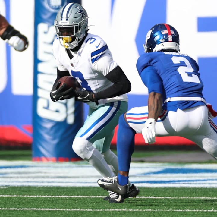 Dallas Cowboys wide receiver George Pickens runs after making a catch as New York Giants cornerback Deonte Banks defends.