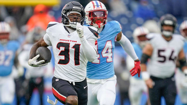 Houston Texans running back Dameon Pierce (31) runs in a touchdown past Tennessee Titans safety Mike Brown (44) during the second quarter at Nissan Stadium in Nashville, Tenn., Sunday, Jan. 5, 2025.