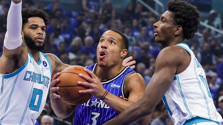 Apr 17, 2026; Orlando, Florida, USA; Orlando Magic guard Desmond Bane (3) goes to the basket against Charlotte Hornets forward Miles Bridges (0) and forward Moussa Diabate (14) during the first quarter during the play-in rounds of the 2026 NBA Playoffs at Kia Center. Mandatory Credit: Mike Watters-Imagn Images