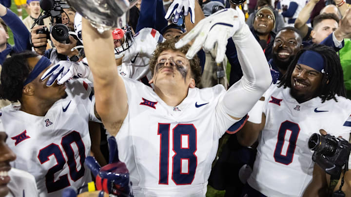 Nov 28, 2025; Tempe, Arizona, USA; Arizona Wildcats wide receiver Brandon Phelps (18) celebrates with the Territorial Cup trophy after defeating the Arizona State Sun Devils in the 99th Territorial Cup at Mountain America Stadium. Mandatory Credit: Mark J. Rebilas-Imagn Images Nov 28, 2025; Tempe, Arizona, USA; Arizona Wildcats wide receiver Brandon Phelps (18) celebrates with the Territorial Cup trophy after defeating the Arizona State Sun Devils in the 99th Territorial Cup at Mountain America Stadium. Mandatory Credit: Mark J. Rebilas-Imagn Images