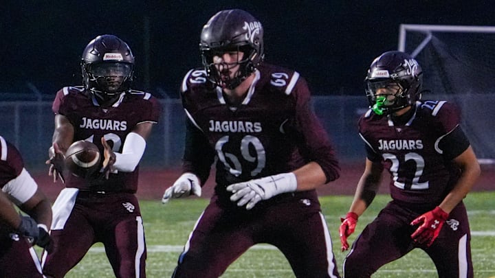Appoquinimink quarterback Desai Drummond takes a snap in front of lineman Layton von Brandt (69) as running back Jayden Triplett works in the backfield in the first quarter in the Jaguars' 34-20 win against Dover at Appoquinimink, Sept 5, 2025.