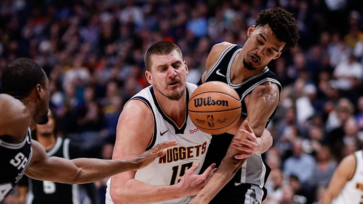 Denver Nuggets center Nikola Jokic (15) battles for a loose ball with San Antonio Spurs center Victor Wembanyama (1) and forward Harrison Barnes (40) in the third quarter at Ball Arena.