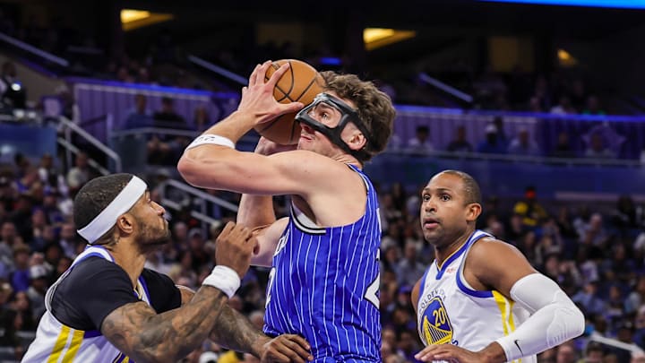 Nov 18, 2025; Orlando, Florida, USA; Orlando Magic forward Franz Wagner (22) is fouled by Golden State Warriors guard Gary Payton II (0) during the second quarter at Kia Center. Mandatory Credit: Mike Watters-Imagn Images