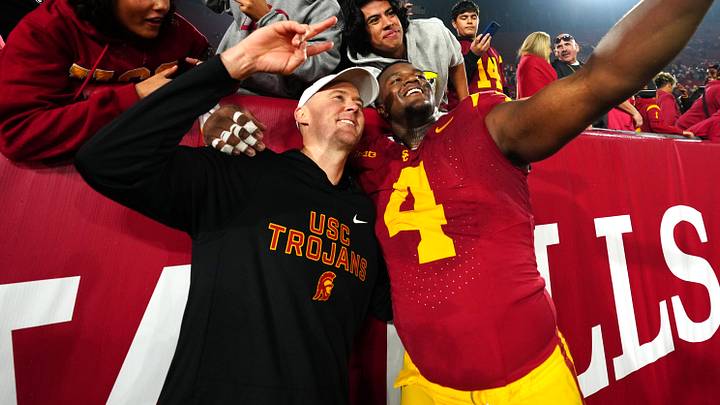 Nov 29, 2025; Los Angeles, California, USA; Southern California Trojans head coach Lincoln Riley (right) and defensive tackle Jahkeem Stewart (4) pose with fans after the game against the UCLA Bruins at United Airlines Field at Los Angeles Memorial Coliseum. Mandatory Credit: Kirby Lee-Imagn Images