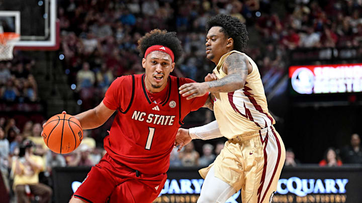 Jan 10, 2026; Tallahassee, Florida, USA; North Carolina State Wolfpack forward Darrion Williams (1) drives to the net past Florida State Seminoles guard Martin Somerville (1) during the first half at Donald L. Tucker Center. Mandatory Credit: Melina Myers-Imagn Images