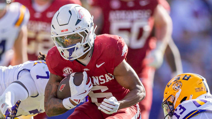 Arkansas Razorbacks wide receiver Raylen Sharpe (6) runs against LSU Tigers defensive back A.J. Haulcy (13) and linebacker Harold Perkins Jr. (7) during the second half at Tiger Stadium.