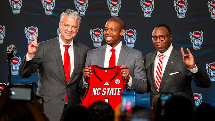 NC State AD Boo Corrigan, men's basketball coach Justin Gainey and Chancellor Kevin Howell pose at Gainey's introductory press conference at the Lenovo Center on Wednesday, April 1, 2026. 