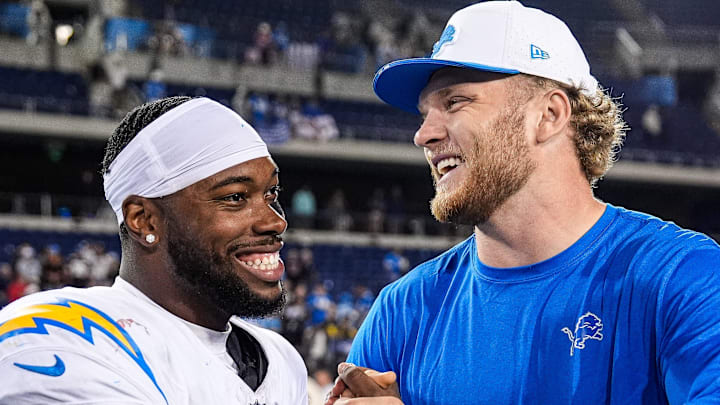 Detroit Lions defensive end Aidan Hutchinson (97) hugs LA Chargers running back Hassan Haskins (28) 