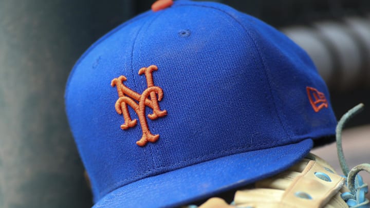 Jul 13, 2022; Atlanta, Georgia, USA; A detailed view of a New York Mets hat and glove in the dugout against the Atlanta Braves in the eighth inning at Truist Park. 
