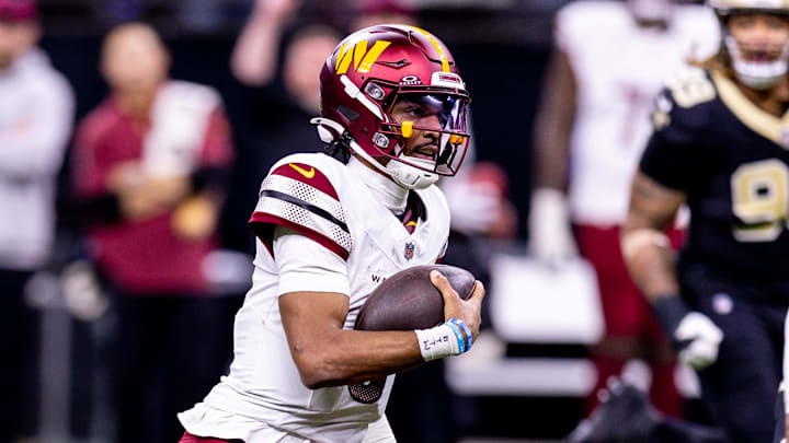 Dec 15, 2024; New Orleans, Louisiana, USA;  Washington Commanders quarterback Jayden Daniels (5) scrambles against the New Orleans Saints during the second half at Caesars Superdome. Mandatory Credit: Stephen Lew-Imagn Images