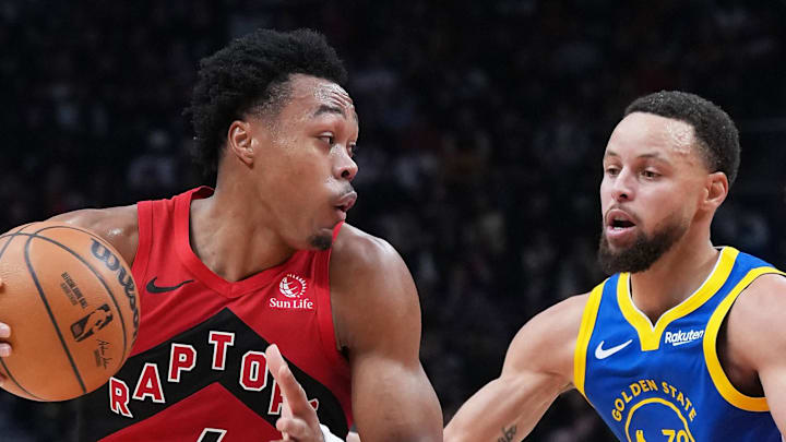 Toronto Raptors forward Scottie Barnes controls the ball as Golden State Warriors guard Stephen Curry tries to defend