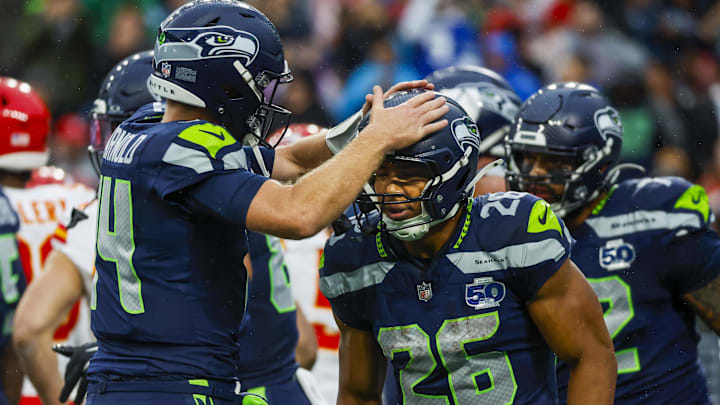Aug 15, 2025; Seattle, Washington, USA; Seattle Seahawks running back Zach Charbonnet (26) celebrates with quarterback Sam Darnold (14) after rushing for a touchdown against the Kansas City Chiefs during the first quarter at Lumen Field.
