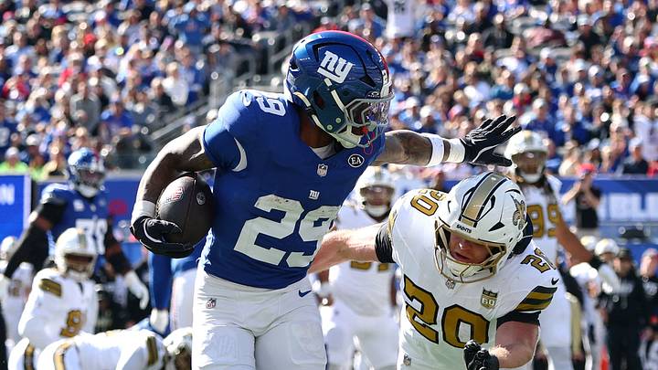 Oct 18, 2026; East Rutherford, New Jersey, USA;  New York Giants running back Tyrone Tracy Jr. (29) runs after a catch for a seventeen-yard touchdown against New Orleans Saints linebacker Pete Werner (20) during the first quarter at MetLife Stadium.   