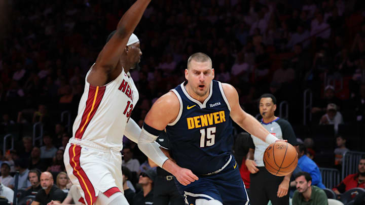 Dec 29, 2025; Miami, Florida, USA; Denver Nuggets center Nikola Jokic (15) drives to the basket against Miami Heat center Bam Adebayo (13) during the first quarter at Kaseya Center. Mandatory Credit: Sam Navarro-Imagn Images
