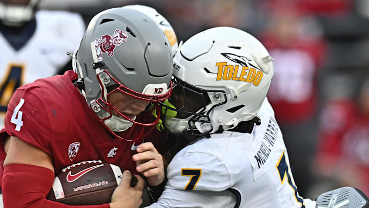 Oct 25, 2025; Pullman, Washington, USA; Washington State Cougars quarterback Zevi Eckhaus (4) is tackled by Toledo Rockets safety Emmanuel McNeil-Warren (7) in the second half at Gesa Field at Martin Stadium. Mandatory Credit: James Snook-Imagn Images