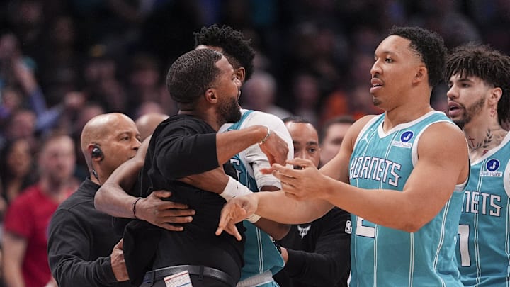 Feb 9, 2026; Charlotte, North Carolina, USA;  Charlotte Hornets forward Brandon Miller (24) and forward Grant Williams (2) hold back Head Coach Charles Lee after his ejection during the second half against the Detroit Pistons at Spectrum Center. Mandatory Credit: Jim Dedmon-Imagn Images