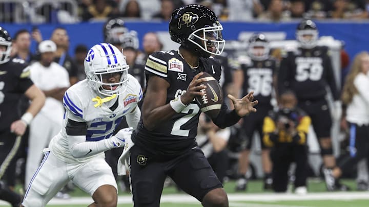 Dec 28, 2024; San Antonio, TX, USA; Colorado Buffaloes quarterback Shedeur Sanders (2) runs with the ball as Brigham Young Cougars cornerback Evan Johnson (21) attempts to make a tackle during the third quarter at Alamodome. Mandatory Credit: Troy Taormina-Imagn Images