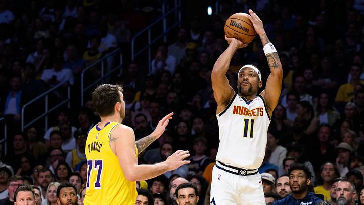 Mar 14, 2026; Los Angeles, California, USA; Denver Nuggets guard Bruce Brown (11) shoots over Los Angeles Lakers guard Luka Doncic (77) during the second half at Crypto.com Arena. Mandatory Credit: William Liang-Imagn Images
